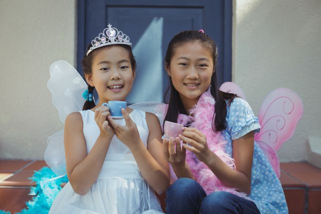 Portrait of siblings in fairy costume having a tea party at home