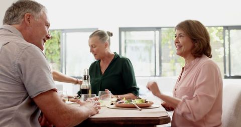 Diverse Friends Enjoying Meal and Conversation at Cozy Dining Table