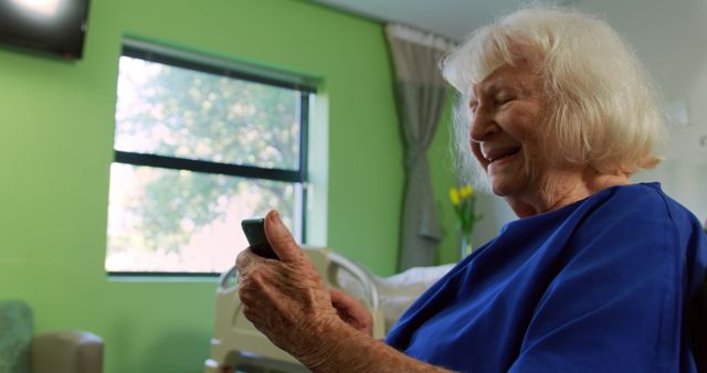 Elderly Woman Smilingly Using Smartphone in Hospital Room - Download Free Stock Images Pikwizard.com