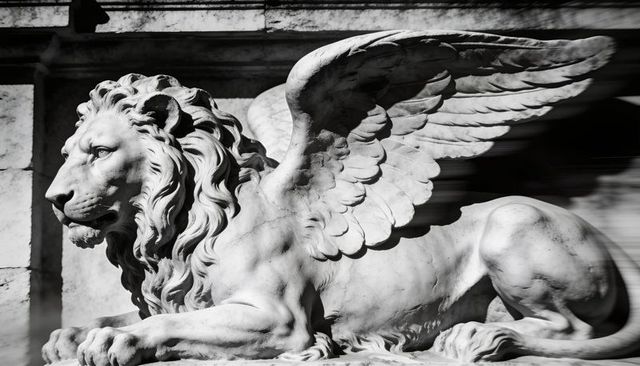 Reclining winged lion sculpture on weathered stone plinth dramatic classical guardian