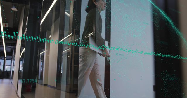 Business professional walking through modern office with digital holographic data visualization - Download Free Stock Images Pikwizard.com