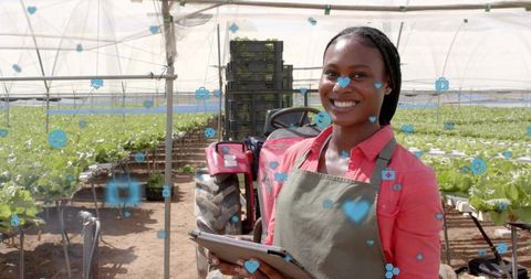 Smiling Woman with Tablet in Greenhouse Lettuce Field