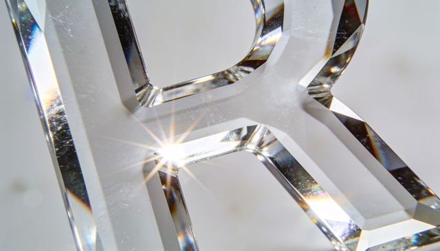 Glinting faceted crystal letter r refracting light with starburst highlight and prism