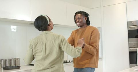 African American Couple Holding Hands Smiling in Modern Kitchen Sharing Romantic Moment