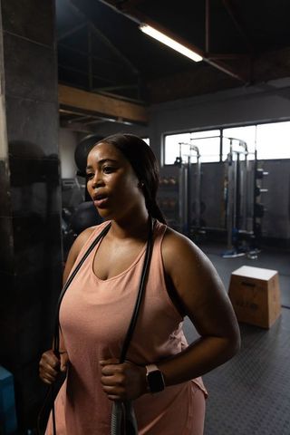 African american woman training with resistance band in industrial gym building endurance
