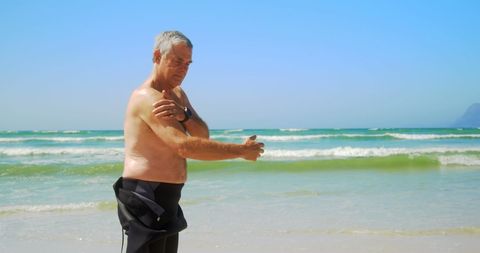 Senior Surfer Applying Sunscreen on Sunny Beach - Download Free Stock Images Pikwizard.com