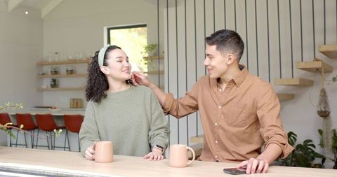 Couple Enjoying Warm Beverages in Modern Minimalist Kitchen