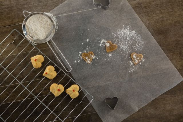 Close-up of sieve with icing sugar cookies on cooling rack