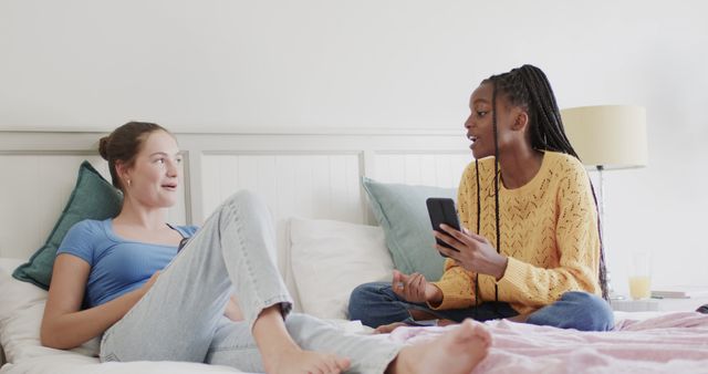 Teen Girls Relaxing on Bed Sharing Earbuds and Smartphones - Download Free Stock Images Pikwizard.com