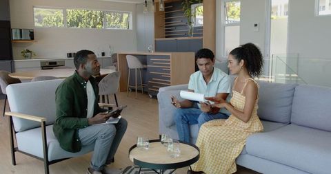 Diverse Couple Consulting with Financial Advisor in Modern Living Room
