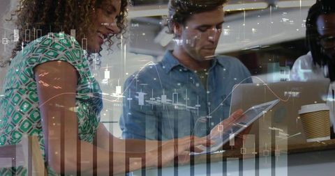 Collaborating trio using laptops and tablet at cafe counter with financial charts overlay