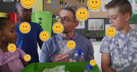 Teacher Guiding Students Sorting Plastics for Classroom Recycling Project with Green Bins