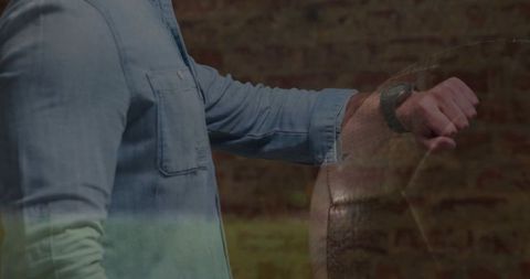 Person holding leather training ball showing wristwatch