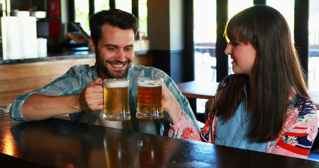Happy couple interacting while having beer in pub
