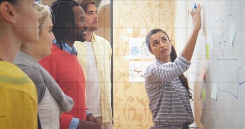 Team collaborating around office whiteboard for brainstorming session