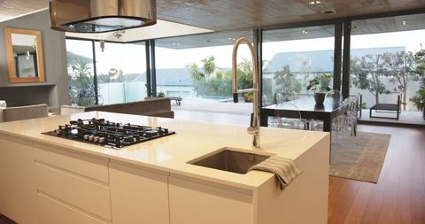 Sleek Open-Concept Kitchen with Modern White Island Overlooking Bright Terrace