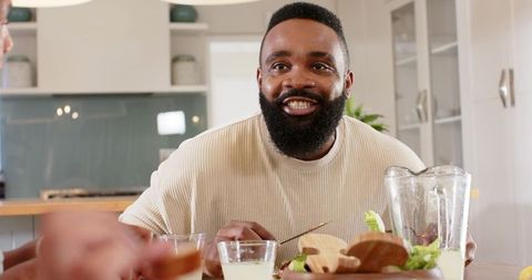 Man Smiling Over Breakfast Meeting in Modern Kitchen
