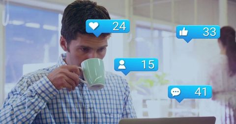 Man Engaged with Digital Notifications While Working in Office