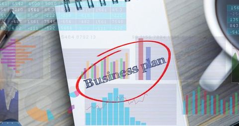 Red-circled business plan notebook showing financial charts analytics minimalist workspace