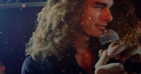 Young male performer sings on stage with dynamic lighting