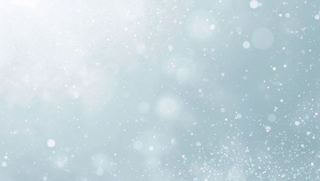 Soft pale blue bokeh background with glowing light flare and drifting particles