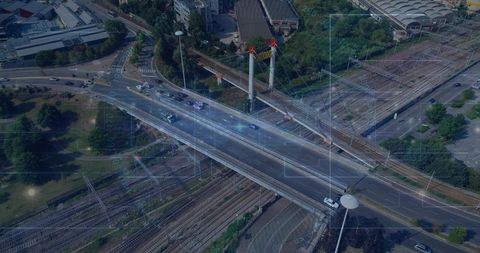 Aerial cable-stayed overpass crossing urban rail yard with multilane traffic and greenery