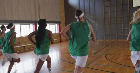Female Basketball Team Running Drills in Gymnasium