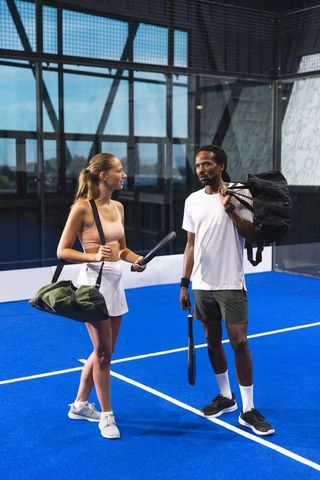 Diverse athletes enjoying rooftop padel game in urban setting