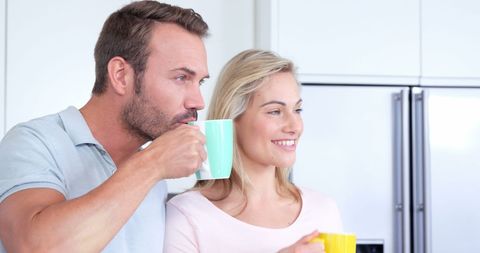 Smiling Couple Enjoying Hot Drink in Modern Kitchen