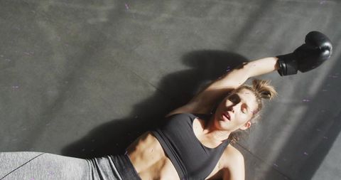 Lying boxer catching breath after intense training showing core strength and determination