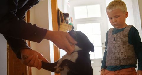 Father and Son Bonding with Pet Dog at Home