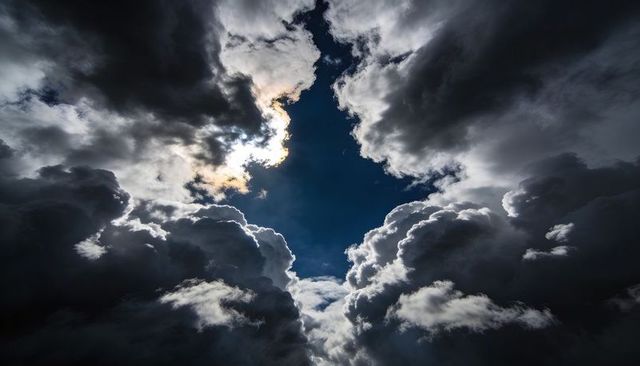 Dramatic Cumulonimbus Opening Revealing Deep Blue Sky with Silver-Lined Backlit Clouds