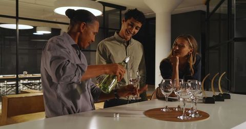 Diverse team socializing with drinks at office gathering