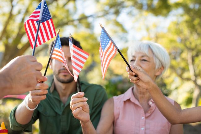 Family holding american flags in the park on a sunny day