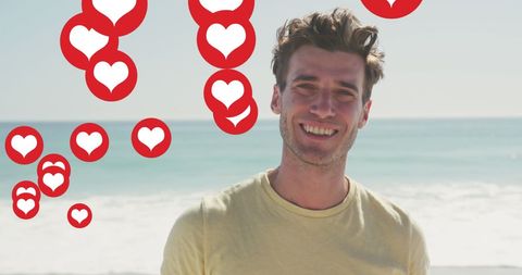 Smiling man on beach surrounded by social media heart icons