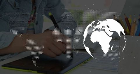 Creative artistic workspace with digital drawing tablet and world map overlay