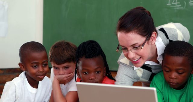 Smiling Teacher and Engaged Students Using Laptop in Classroom - Download Free Stock Images Pikwizard.com