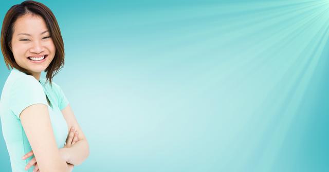 Smiling Woman with Arms Crossed Against Sky Blue Background - Download Free Stock Photos Pikwizard.com