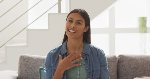 Smiling Woman Talking While Sitting on Sofa in Modern Home Interior - Download Free Stock Images Pikwizard.com