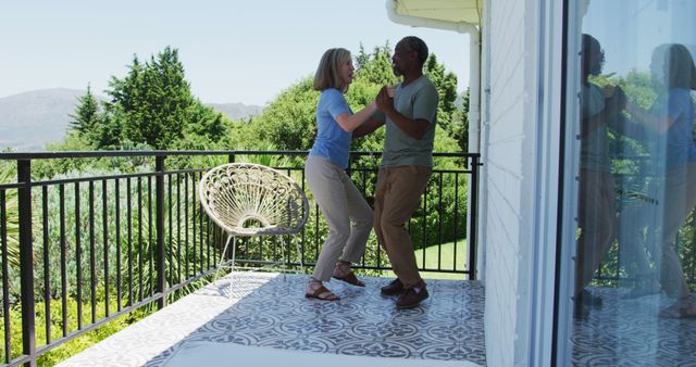 Biracial senior couple dancing together in the balcony at home. staying at home in self isolation in quarantine lockdown