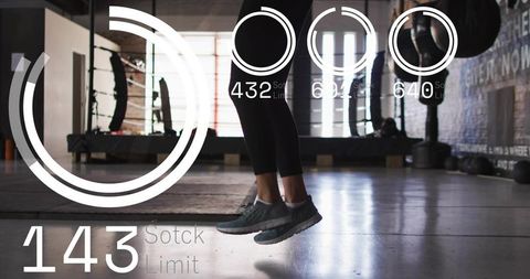 Backlit jumping woman lower legs in gym with futuristic hud fitness readouts and analytics