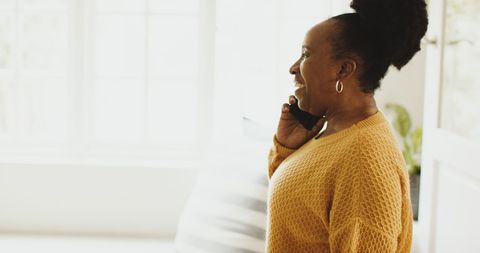 Older African American Woman Smiling While Talking on Smartphone at Home