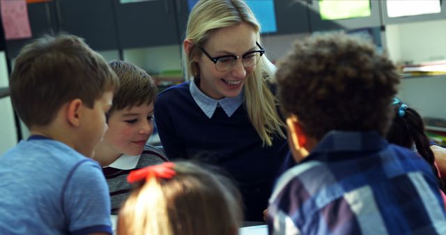 Smiling Teacher Engaging with Young Students in Classroom - Download Free Stock Images Pikwizard.com