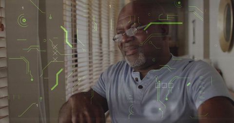 Contemplating senior man adjusting glasses by window with green futuristic hud overlay