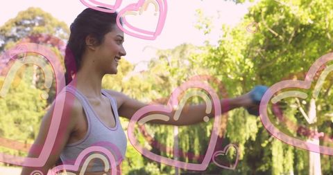 Joyful woman exercising outdoors with pink heart graphics