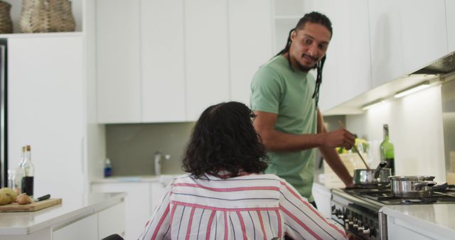 Man Cooking in Kitchen while Woman in Wheelchair Watches - Download Free Stock Images Pikwizard.com