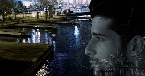 Man blends with nighttime urban landscape in thoughtful gaze