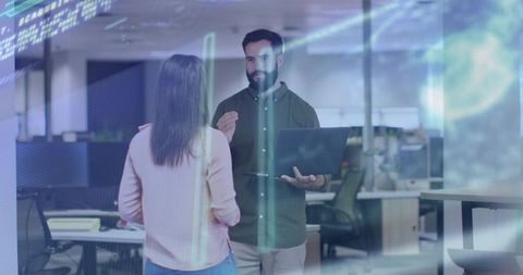 Colleagues discussing digital project in modern open office holding laptop with blue overlay