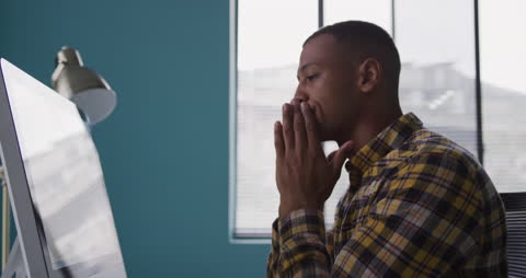 Stressed Biracial Man in Creative Office Contemplating Work