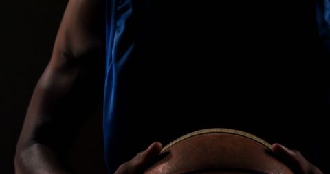 Determined Basketball Player Holding Ball in Dark Studio - Download Free Stock Images Pikwizard.com